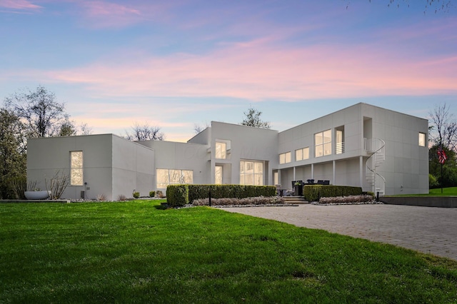 contemporary home with a yard and stucco siding