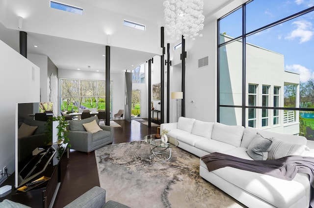 living room with a towering ceiling, wood finished floors, and visible vents