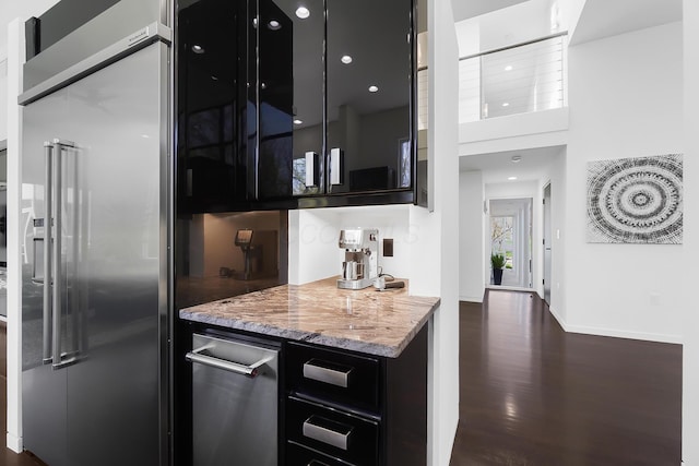 bar with baseboards, high quality fridge, and dark wood-type flooring