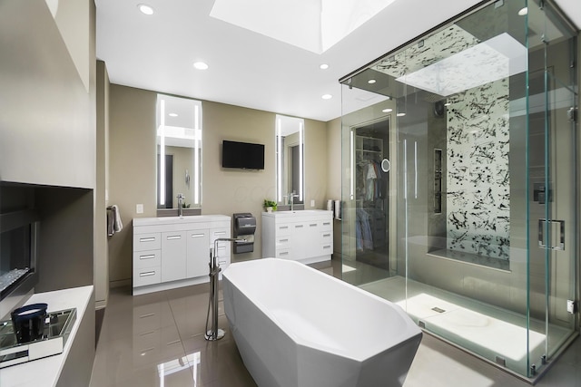 full bathroom featuring recessed lighting, a freestanding tub, vanity, and a stall shower