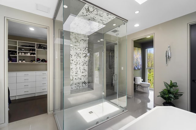 bathroom featuring tile patterned floors, a stall shower, a walk in closet, toilet, and recessed lighting