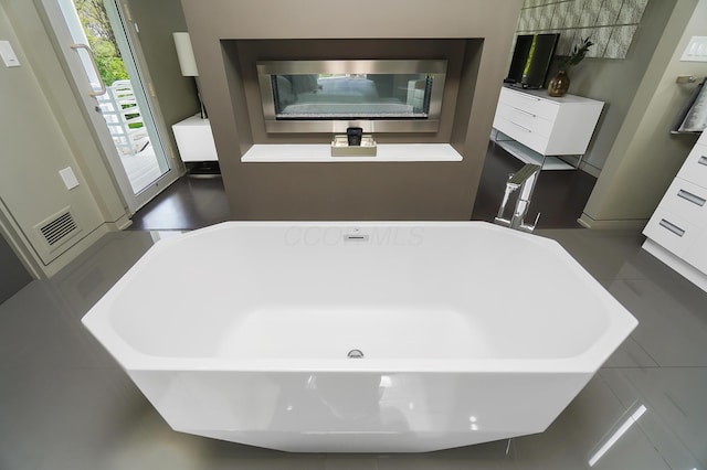 bathroom with a freestanding tub and visible vents