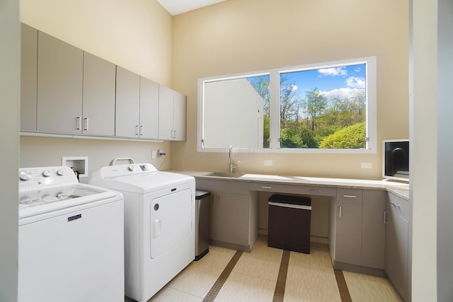 laundry room featuring a towering ceiling, washer and clothes dryer, a sink, light tile patterned flooring, and cabinet space