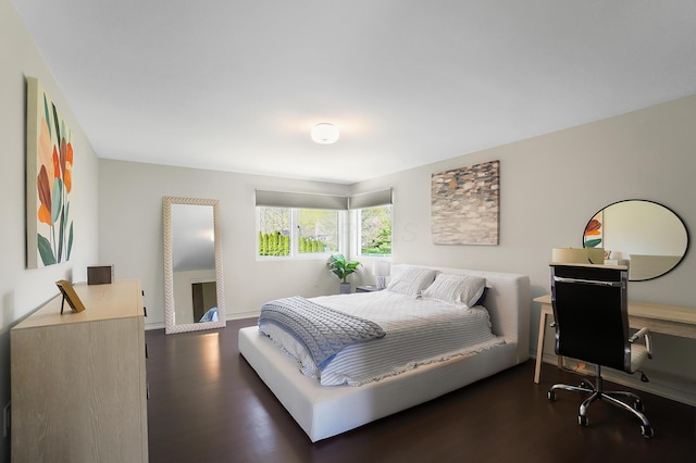 bedroom with baseboards and dark wood-style flooring