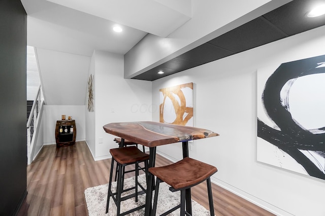 dining space featuring baseboards, wood finished floors, and recessed lighting
