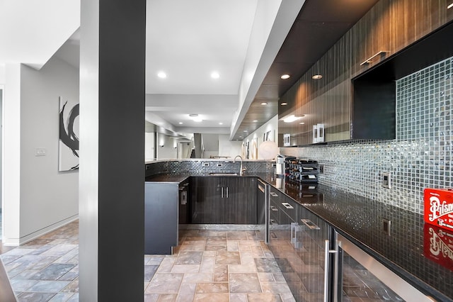 kitchen featuring stone finish floor, wine cooler, a sink, and modern cabinets
