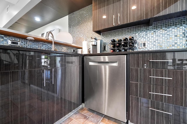 kitchen with modern cabinets, stainless steel dishwasher, visible vents, and decorative backsplash