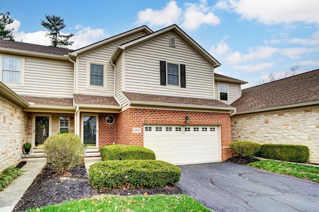3995 Kensingwood Dr, Columbus, OH 43230 - view of front facade with a shingled roof, an attached garage, brick siding, and aphalt driveway