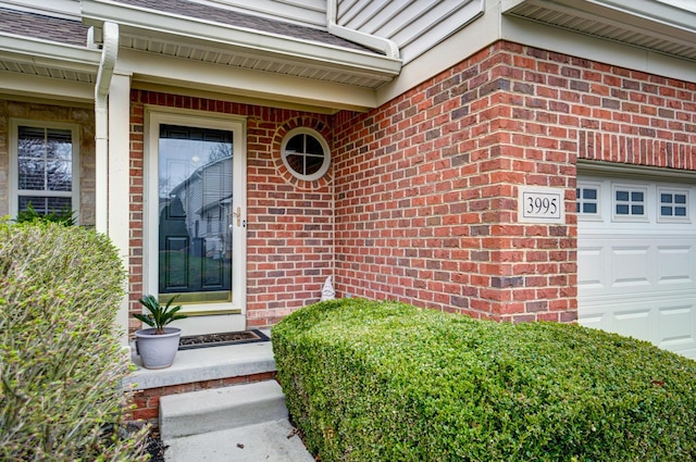 3995 Kensingwood Dr, Columbus, OH 43230 - doorway to property featuring a garage, brick siding, and roof with shingles
