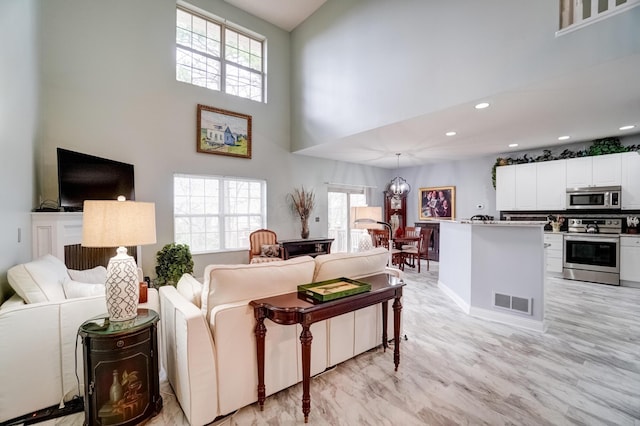 3995 Kensingwood Dr, Columbus, OH 43230 - living room with a high ceiling, visible vents, recessed lighting, and a notable chandelier