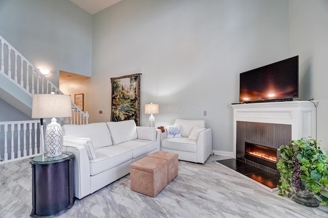 3995 Kensingwood Dr, Columbus, OH 43230 - living area featuring a high ceiling, marble finish floor, a warm lit fireplace, and stairs
