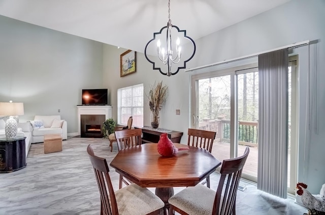 3995 Kensingwood Dr, Columbus, OH 43230 - dining room featuring an inviting chandelier, marble finish floor, a towering ceiling, and a fireplace with flush hearth