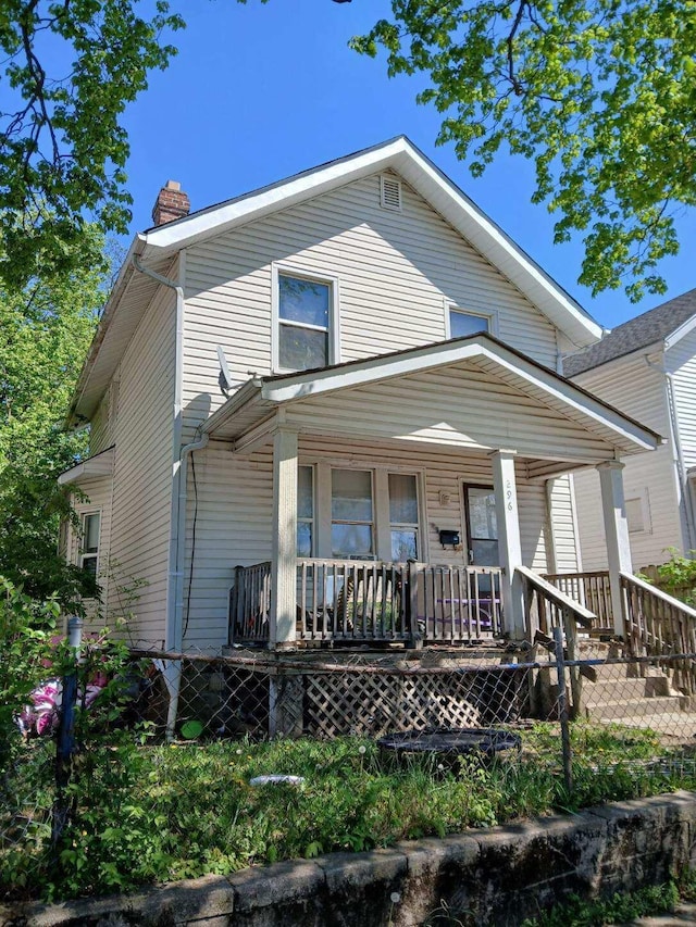 view of front of property featuring a chimney and covered porch
