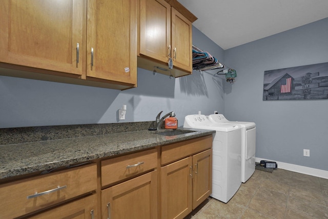 laundry area with washing machine and clothes dryer, baseboards, a sink, and cabinet space