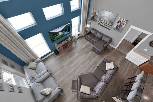 living room featuring wood finished floors and a towering ceiling