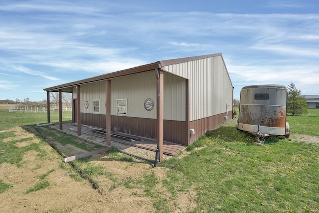 view of side of home featuring a lawn and an outbuilding