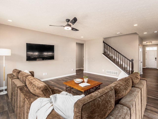 living room with baseboards, visible vents, stairway, and wood finished floors