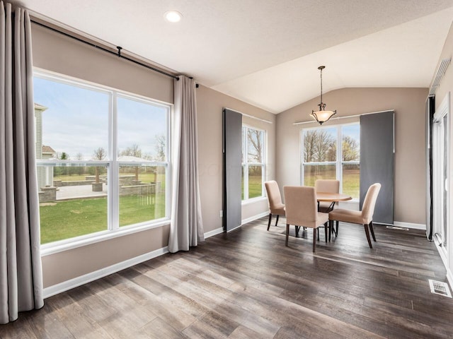 dining area with baseboards, visible vents, wood finished floors, and lofted ceiling