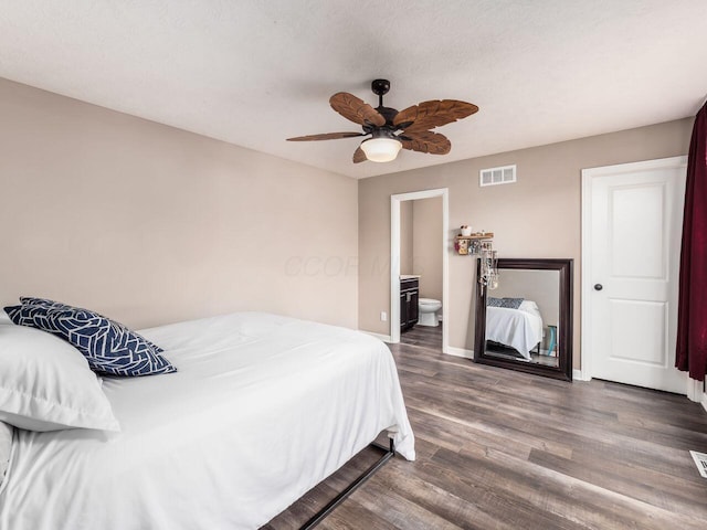 bedroom with baseboards, connected bathroom, visible vents, a ceiling fan, and wood finished floors