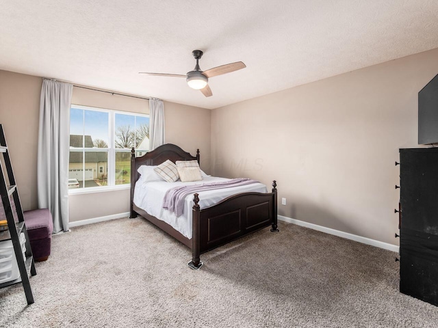 carpeted bedroom with baseboards, ceiling fan, and a textured ceiling