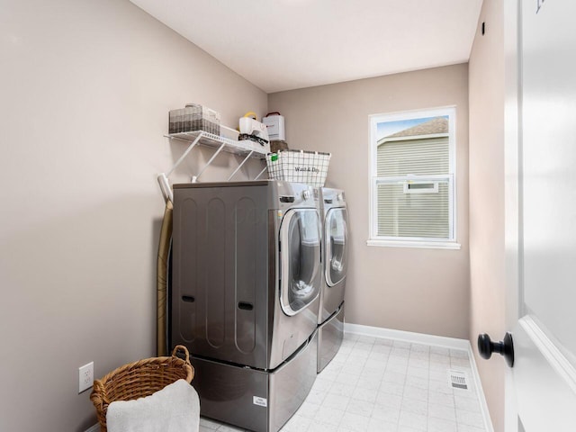 washroom with independent washer and dryer, visible vents, laundry area, and baseboards