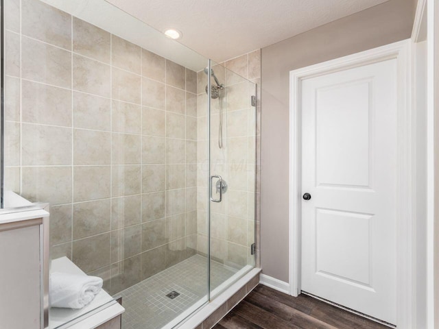 bathroom with wood finished floors and a stall shower
