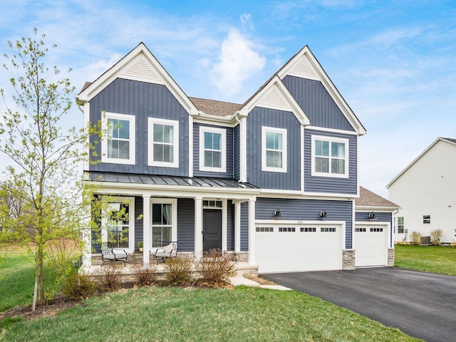 view of front of property featuring cooling unit, board and batten siding, aphalt driveway, a porch, and a garage