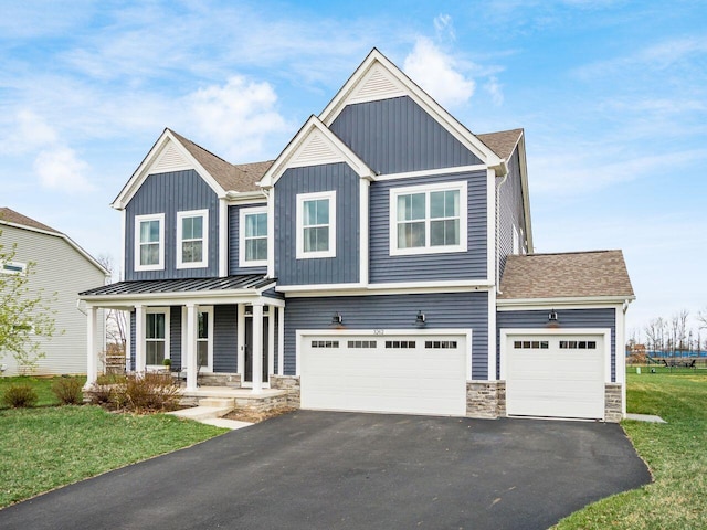 view of front of house featuring stone siding, board and batten siding, aphalt driveway, covered porch, and a garage