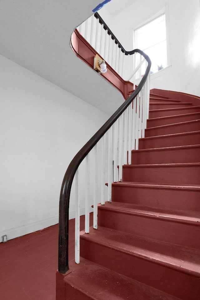 stairway with wood finished floors and baseboards
