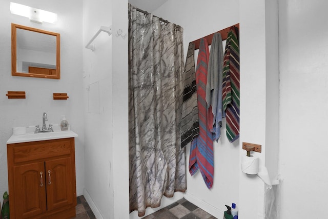 bathroom with a shower with curtain, vanity, and baseboards