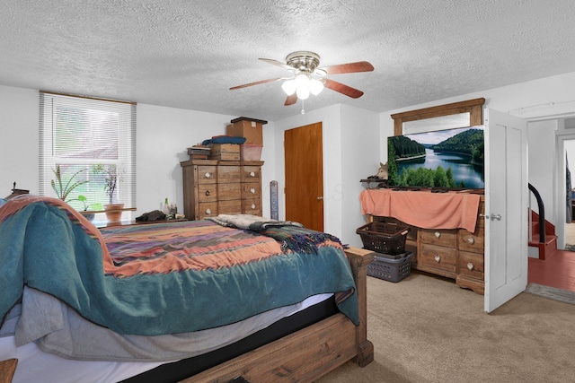 bedroom featuring a textured ceiling, light carpet, and a ceiling fan