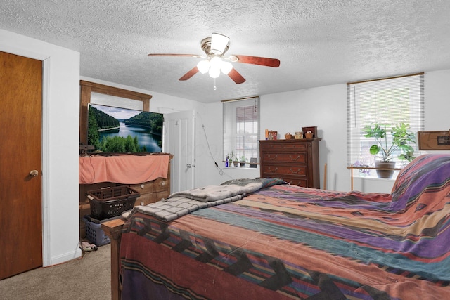 bedroom featuring carpet, a textured ceiling, and a ceiling fan