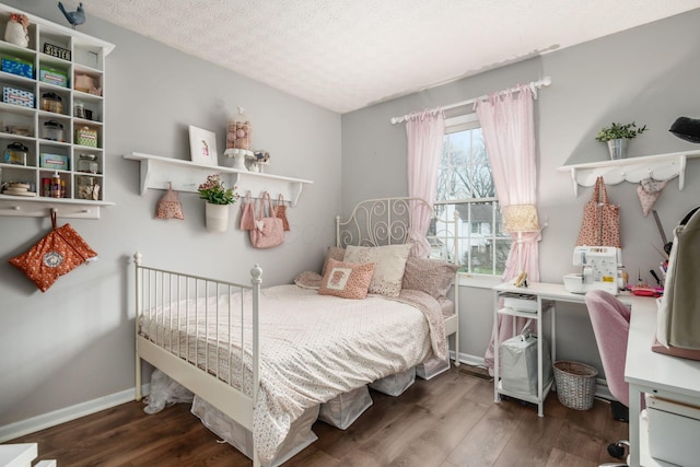 bedroom with a textured ceiling, baseboards, and wood finished floors