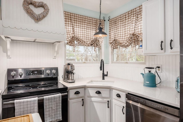 kitchen with pendant lighting, electric range, white cabinetry, dishwasher, and a sink