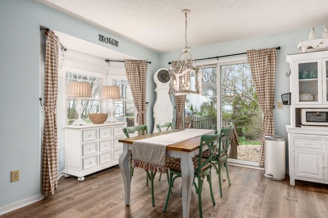 dining space with a chandelier, wood finished floors, and a wealth of natural light