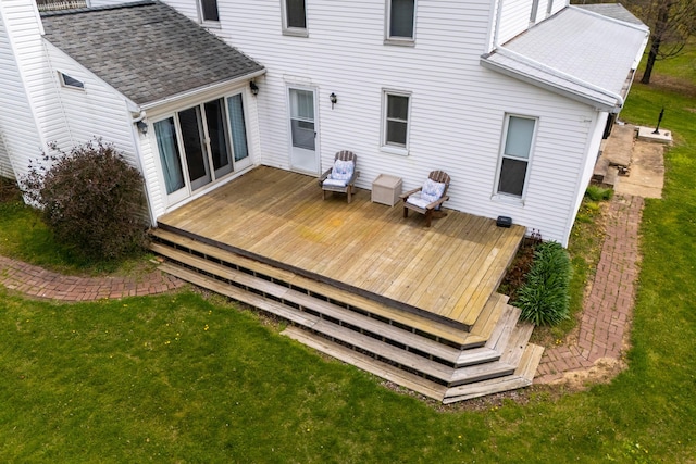 rear view of property featuring a yard, roof with shingles, and a deck