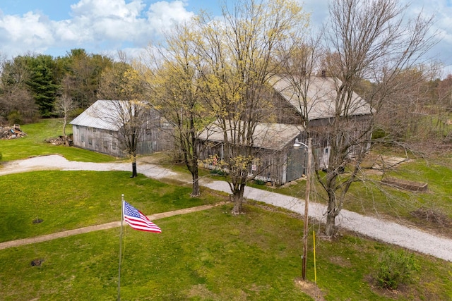 view of community featuring an outdoor structure, a barn, and a lawn