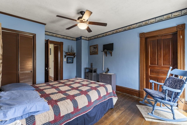 bedroom with baseboards, a closet, ornamental molding, a ceiling fan, and dark wood finished floors