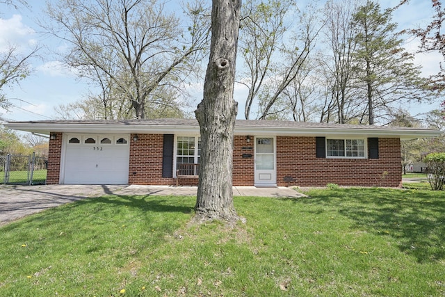 single story home featuring a garage, driveway, fence, a front yard, and brick siding