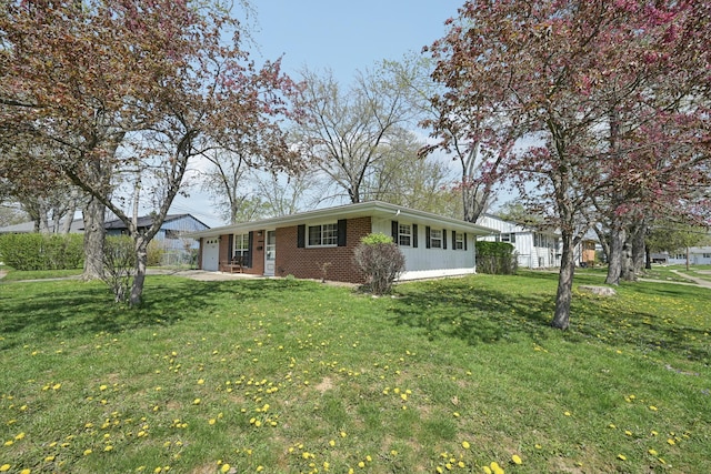 view of front facade featuring brick siding, a front yard, and a garage