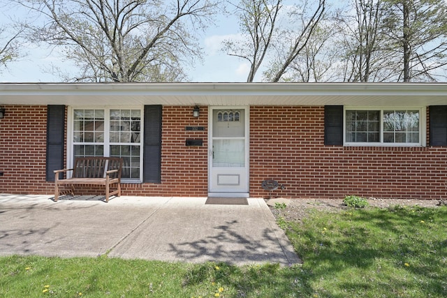 view of exterior entry featuring brick siding
