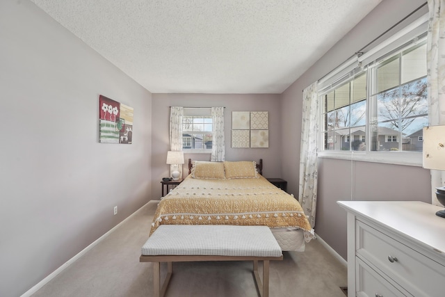 bedroom with baseboards, a textured ceiling, and light colored carpet