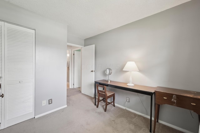 office with a textured ceiling, carpet flooring, and baseboards