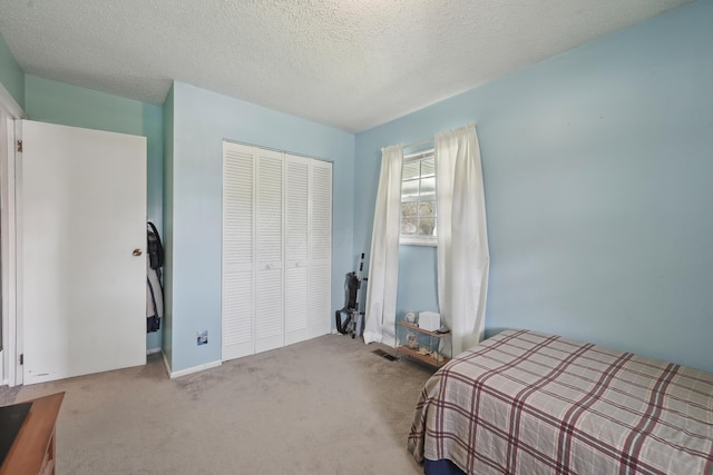 carpeted bedroom with a textured ceiling and a closet