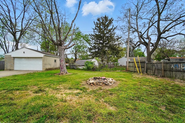 view of yard featuring fence, a detached garage, and an outbuilding