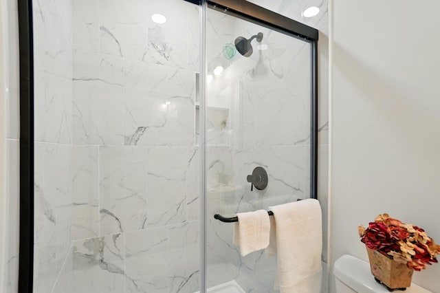 bathroom with a stall shower and toilet