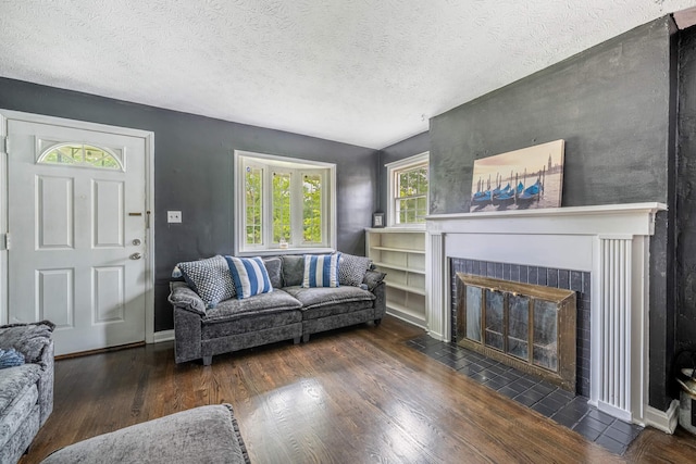 624 W 1st St, Springfield, OH 45504 - living room with wood finished floors, a brick fireplace, a textured ceiling, and baseboards