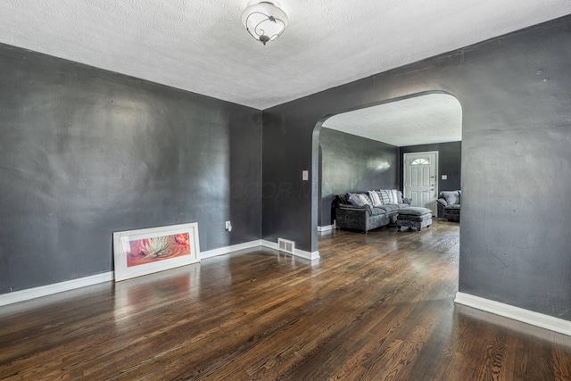 624 W 1st St, Springfield, OH 45504 - living area featuring arched walkways, wood finished floors, baseboards, and a textured ceiling