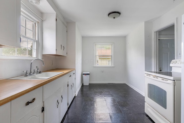 624 W 1st St, Springfield, OH 45504 - kitchen with white range with electric cooktop, a sink, white cabinets, and baseboards