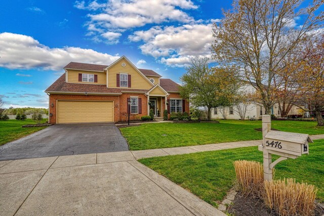traditional-style house featuring a front yard, brick siding, an attached garage, a shingled roof, and driveway